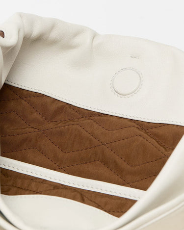 Cream leather bag interior with brown quilted lining, white trim, and embossed circle detail. Medium Gather Bag Set.