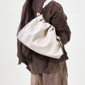 Medium Gather Bag Set in Cloud white Nappa leather with adjustable straps, worn by a model.
