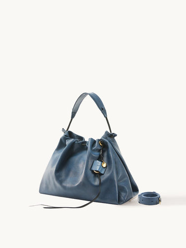 Medium Gather Bag Set in navy blue Nappa leather with gold hardware and adjustable strap.