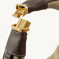 Close-up of Large Luna Hobo Bag's gold clasp mechanism in Dune Suede, showing the Songmont logo.