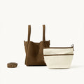 Medium Song Bag in Agarwood nubuck leather with a cream canvas inner pouch and adjustable strap.