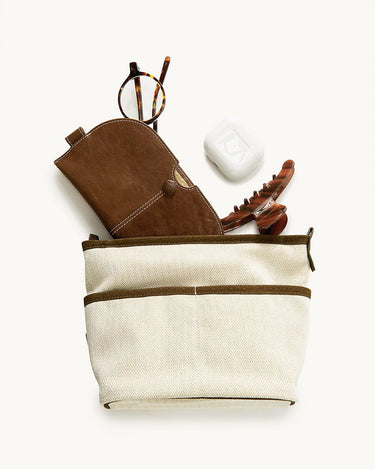 Medium Song Bag in cream canvas with brown leather accents, featuring glasses, AirPods case, and claw clip.