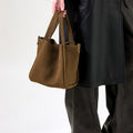 Medium Song Bag in Agarwood nubuck leather, structured trapezoid shape, double handles.