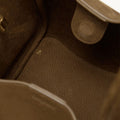 Inside view of the Medium Song Bag in Agarwood, showing the textured leather interior and a magnetic closure tab.