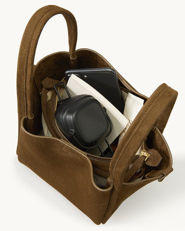 Medium Song Bag in Agarwood Nubuck leather, with phone and black headphones inside