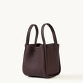 Medium burgundy Song Bag crafted from full-grain leather with a structured base and dual top handles.