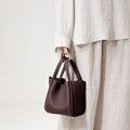 Medium burgundy Song Bag in pebble leather with gold hardware. Structured design, ideal for work and travel.