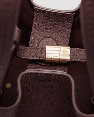 Medium Song Bag burgundy leather interior with brass closure and embossed Songmont logo.