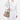 Medium Song Bag in Taupe: A pebbled leather bucket bag worn by a person in a white outfit.