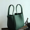 Medium Song Bag in emerald green with pebbled leather texture and structured bucket design