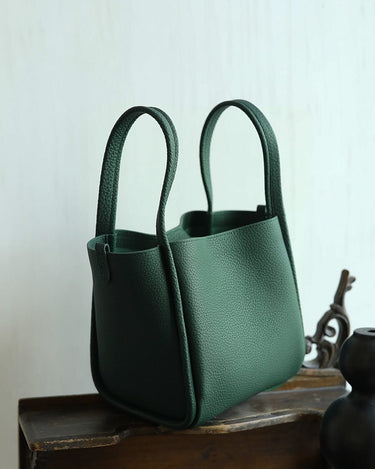 Medium Song Bag in emerald green with pebbled leather texture and structured bucket design