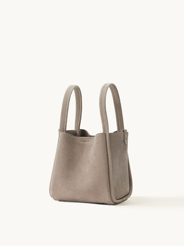 Medium Song Bag in Haze nubuck leather, structured O-shape design with dual top handles.
