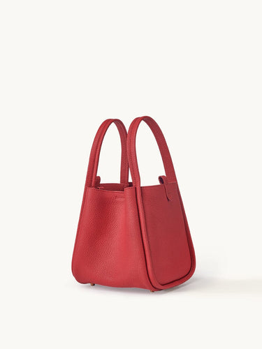 Medium Song Bag in Lucky Red full-grain leather, a structured bucket bag with dual top handles and protective metal feet.