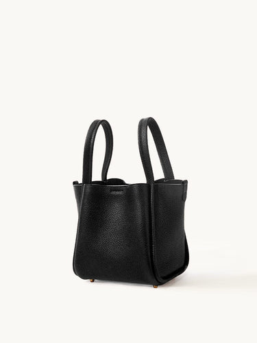 Medium Song Bag in black full-grain leather with dual top handles and protective metal feet.