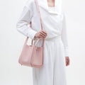 Medium Song Bag in Pink: A pebble leather bucket bag with a top handle and adjustable strap, perfect for everyday elegance.