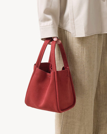 Medium Song Bag in vibrant Poppy red nubuck leather with a unique O-shaped structure and twin top handles.