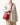 Medium Song Bag in Poppy red leather, featuring textured finish and gold hardware, worn by a model.