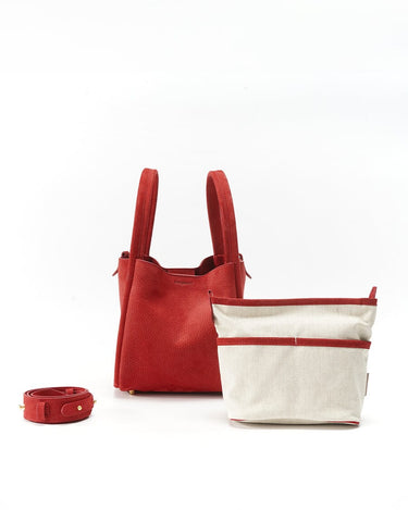 Red Songmont Medium Bag with ivory canvas inner pouch and red strap, showcasing nubuck texture.
