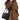 Medium Song Bag in Eco Onyx: black vegan leather bucket bag with gold hardware, worn by model in brown coat.