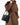 Medium Song Bag in Eco Onyx: black vegan leather bucket bag with gold hardware, worn by model in brown coat.