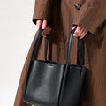 Medium Song Bag in Eco Onyx vegan leather, featuring a pebbled texture and embossed logo.