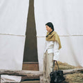 Onyx Medium Yore Duffle Bag: black leather tote with white stitching and gold hardware.
