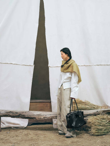 Onyx Medium Yore Duffle Bag: black leather tote with white stitching and gold hardware.