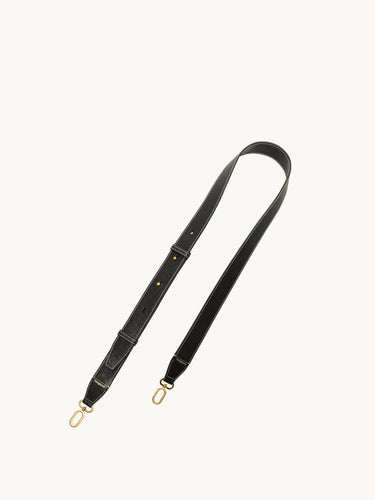 Black leather shoulder strap with white stitching and gold clasps for the Medium Yore Duffle Bag.
