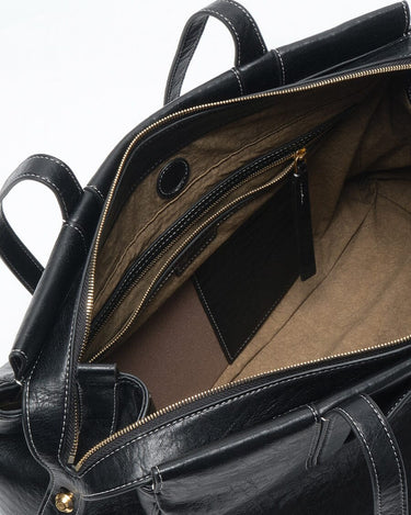 Medium Yore Duffle Bag, vegan leather, Onyx, interior view with compartments and zippered pockets.