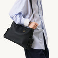 Medium Yore Hobo Bag in Onyx Grain textured leather with gold hardware, worn over the shoulder.