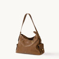 Medium Yore Hobo Bag in Sandal leather with brass hardware and exterior pockets. Stylish and versatile.