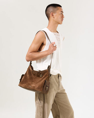 Medium Yore Hobo Bag: Sandal Suede. Brown suede and leather hobo bag with multiple pockets, worn by a model.
