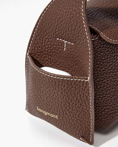 Brown pebbled leather Mini Drippy Roof Bag, white stitching, front pocket with earbud case, Songmont logo.