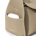 Mini Drippy Roof Bag in Cobble: Textured leather, gold 'Songmont' logo, and exterior pocket holding earbuds.