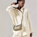 Pebbled leather Mini Drippy Roof Bag in Cobble, crossbody style with gold hardware, worn with a linen outfit.