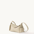 Ivory Mini Drippy Roof Bag in textured leather, showcasing its unique architectural-inspired shape and adjustable strap.