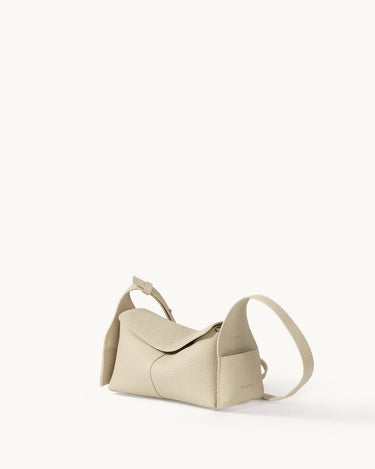 Ivory Mini Drippy Roof Bag in textured leather, showcasing its unique architectural-inspired shape and adjustable strap.