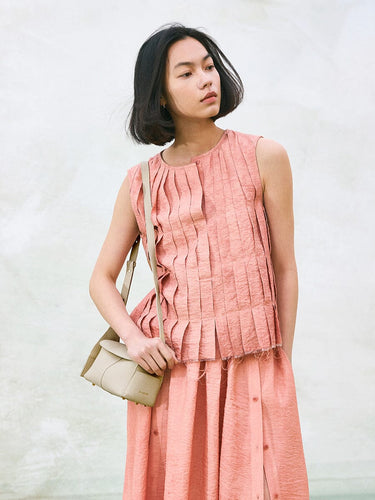 Mini Drippy Roof Bag in Ivory, textured leather crossbody bag with flap, worn with pleated pink outfit.