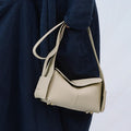 Mini Drippy Roof Bag in Ivory: A compact, pebbled leather handbag with gold hardware and a minimalist design.