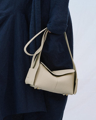Mini Drippy Roof Bag in Ivory: A compact, pebbled leather handbag with gold hardware and a minimalist design.