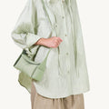 Mini Drippy Roof Bag in light green full-grain leather with flap closure and gold hardware.