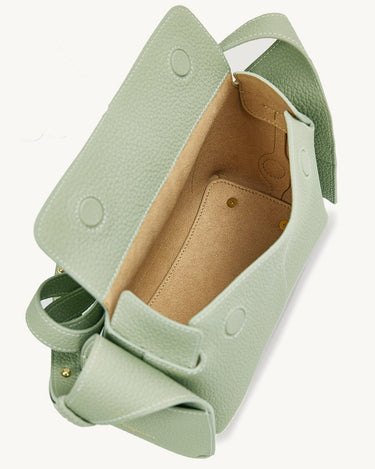 Pale green full-grain leather mini bag with adjustable strap and stainless steel hardware.