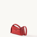 Red full-grain leather Mini Drippy Roof Bag with white stitching and adjustable strap.