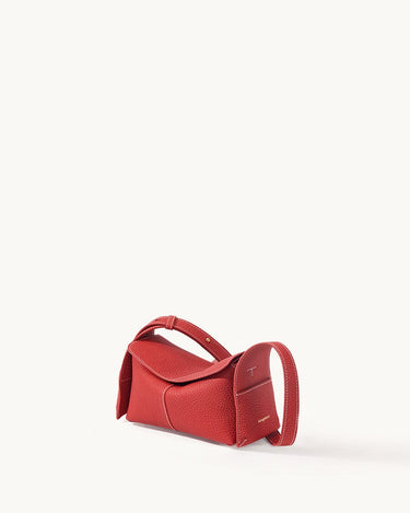 Red full-grain leather Mini Drippy Roof Bag with white stitching and adjustable strap.
