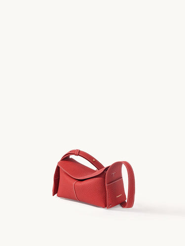 Red full-grain leather Mini Drippy Roof Bag with white stitching and adjustable strap.
