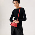 Red full-grain leather Mini Drippy Roof Bag with white stitching and gold hardware, worn by a model.