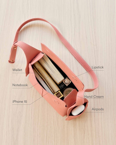 Coral pink leather Mini Drippy Roof Bag interior: wallet, notebook, iPhone 15, lipstick, hand cream, AirPods.