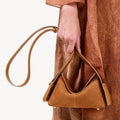 Mini Drippy Roof Bag in Sea Buckthorn textured leather with adjustable strap and gold hardware. Modern sculpted design.