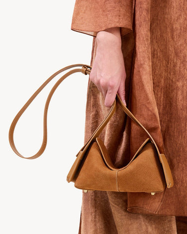 Mini Drippy Roof Bag in Sea Buckthorn textured leather with adjustable strap and gold hardware. Modern sculpted design.