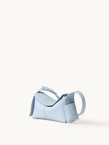 Pale blue full-grain leather mini drippy roof bag with stainless steel hardware and adjustable strap.